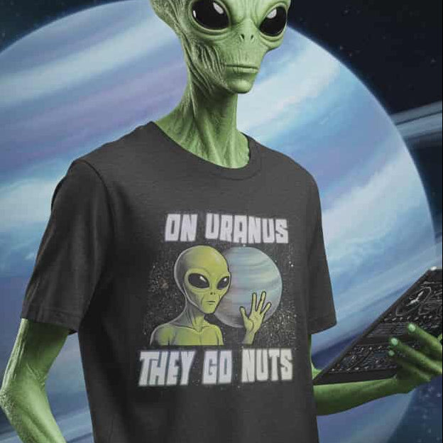 Green alien wearing a t-shirt with an alien graphic and text, set against a space-themed background.